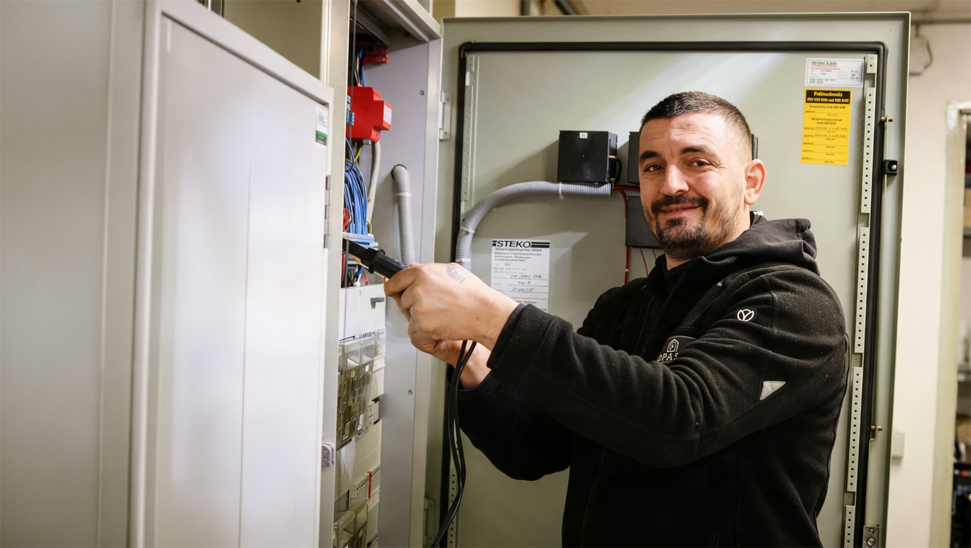 OPASA Elektrofachkraft bei der Prüfung einer Elektroverteilung