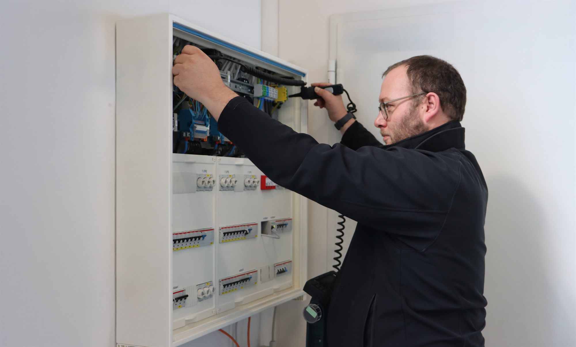 OPASA Elektrofachkraft bei der Arbeit an einer Elektroverteilung
