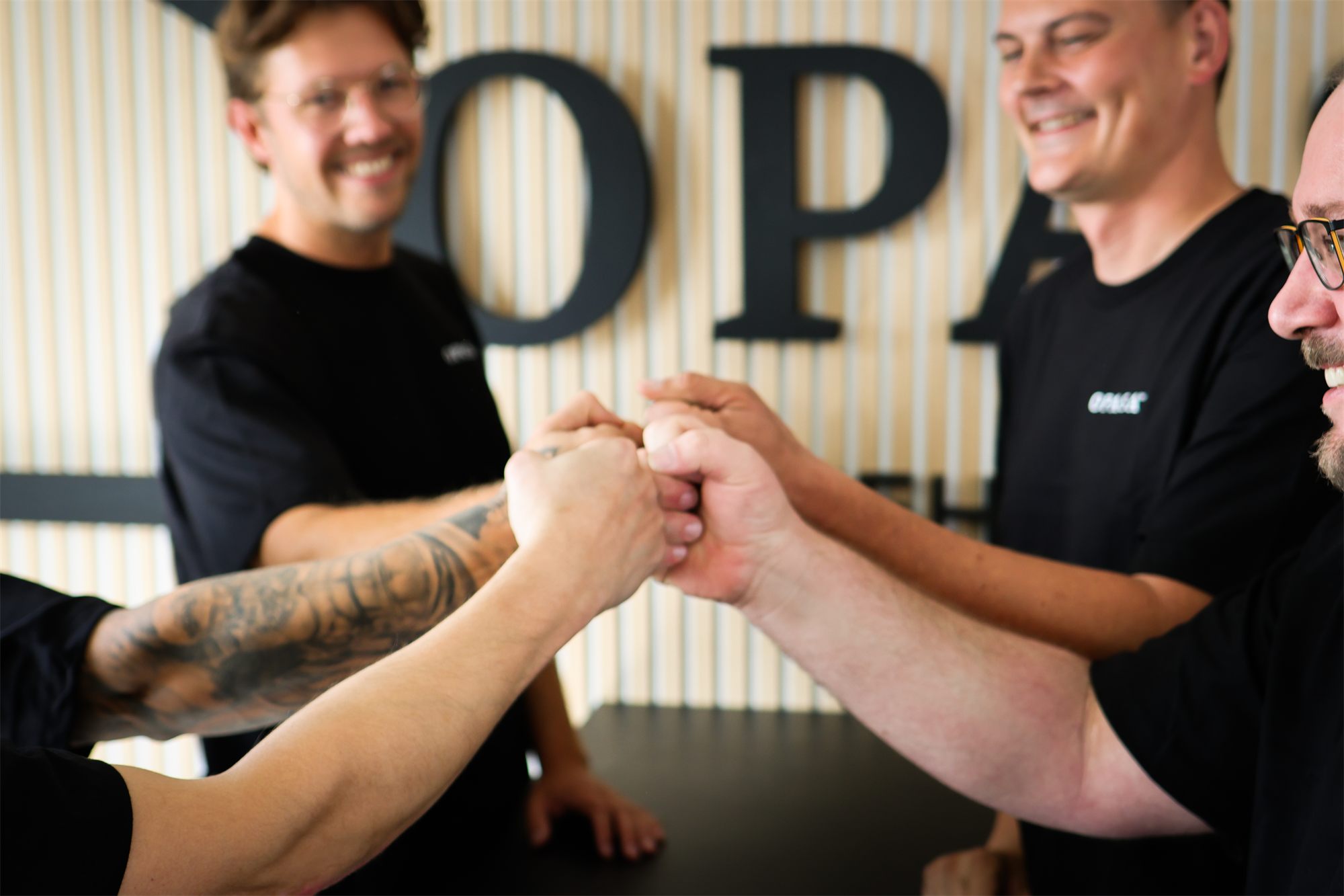 OPASA Team beim Abklatschen vor dem Firmenlogo